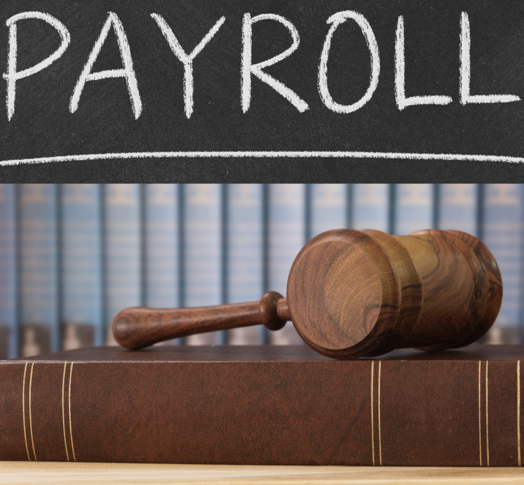 Lohnabrechnung aktuell Holzhammer auf einem Gesetzbuch vor einer Tafel mit der Aufschrift "PAYROLL".